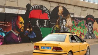 June 2020, Dakar, Senegal: A car drives past a mural by the graffiti artist collective "RBS Crew" picturing the anti-CFA activist Kémi Séba.