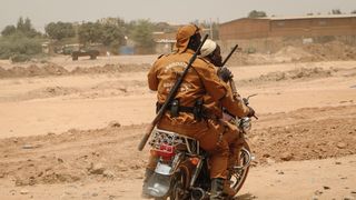 Local defence force volunteers ride on a motorbike through Ouagadougou, part of Burkina Faso