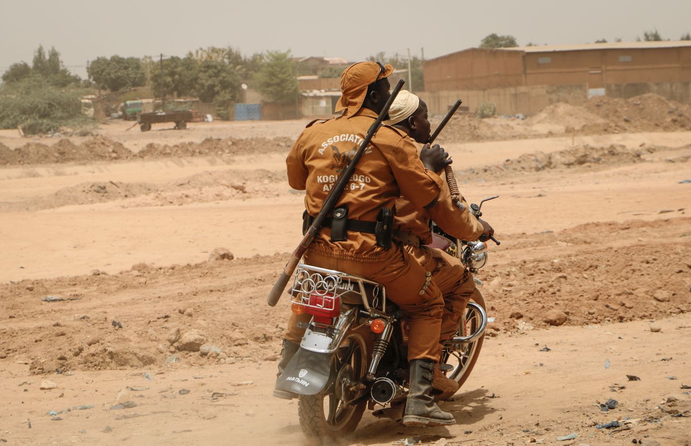 Local defence force volunteers ride on a motorbike through Ouagadougou, part of Burkina Faso