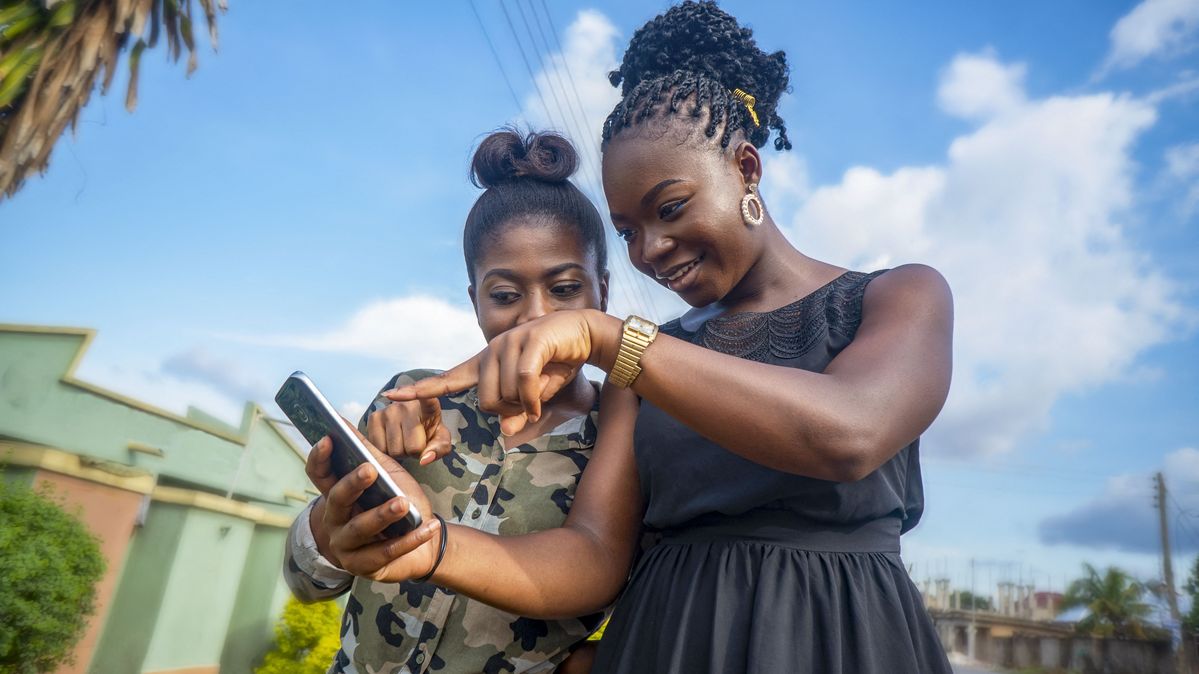 Ghana, 2021: Women looking at a smartphone. 
