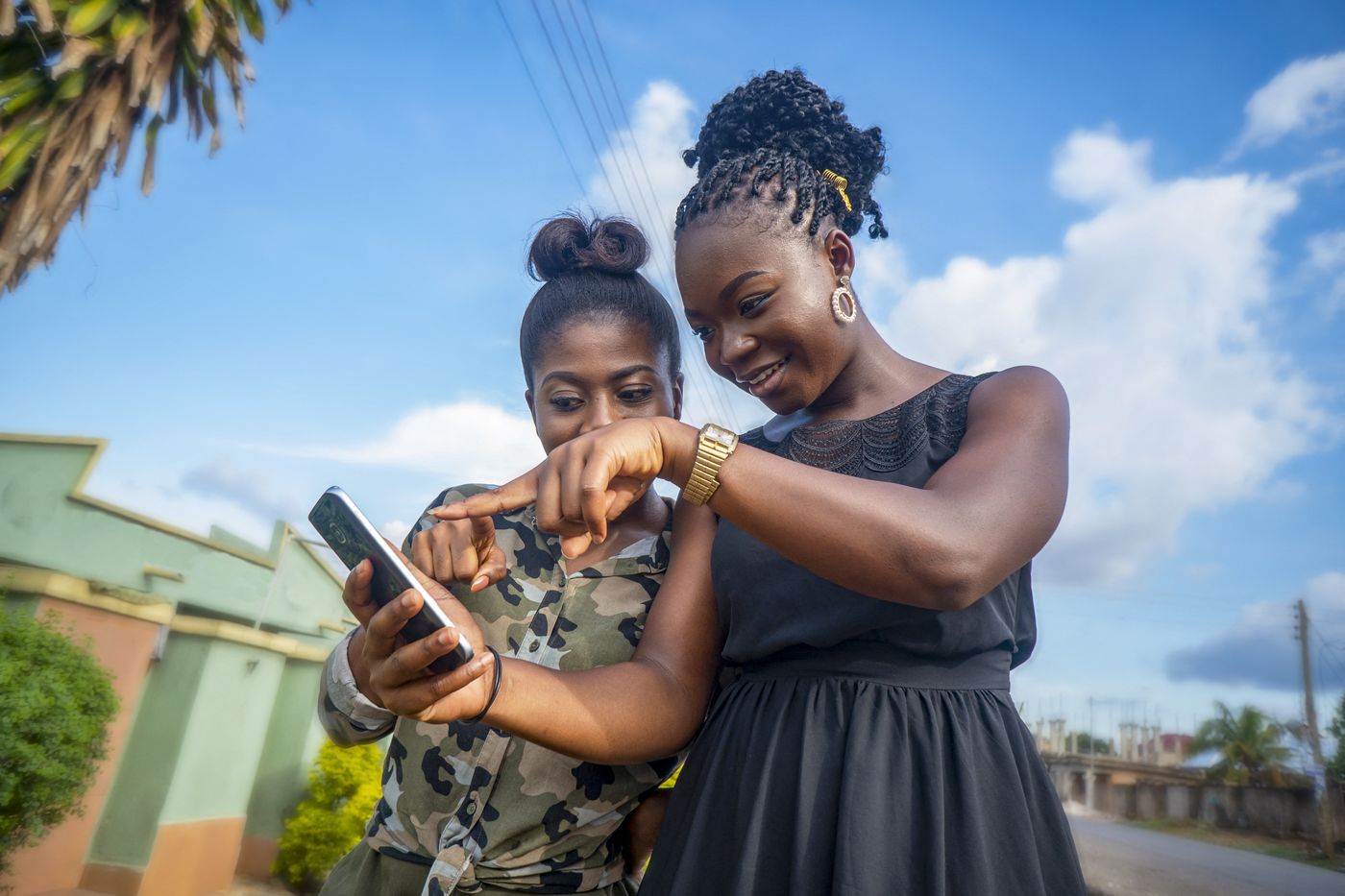 Ghana, 2021: Women looking at a smartphone. 