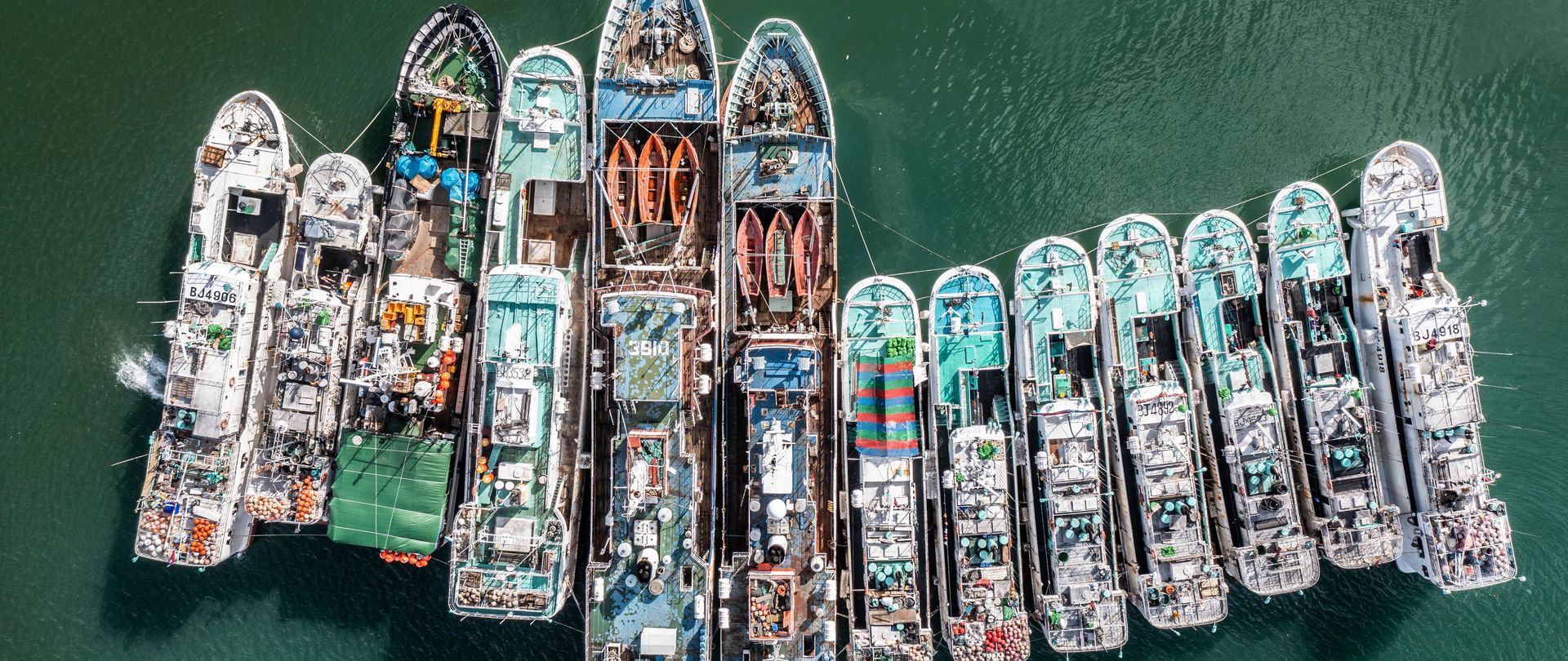 Outside the port of St Louis, Mauritius, cargo ships and bulk carriers wait in an open dock. 